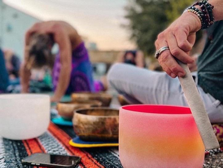 A crystal singing bowl being played during an outdoor group session